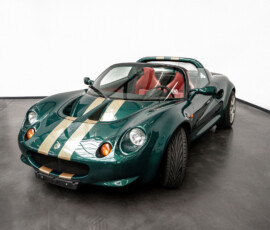 Lotus Elise Roadster in Grün mit goldenen Streifen, Frontansicht von schräg rechts, Verdeck geöffnet.